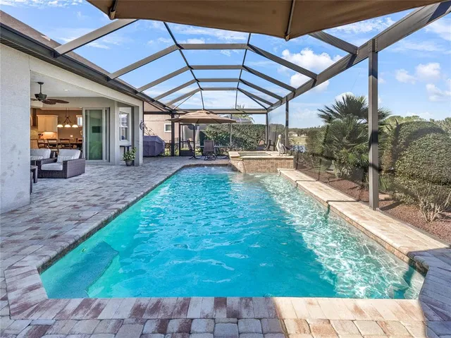 a view of swimming pool with outdoor seating and a garden