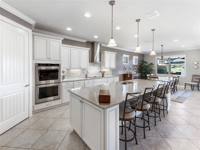 a dining room with stainless steel appliances kitchen island granite countertop a dining table chairs and view kitchen