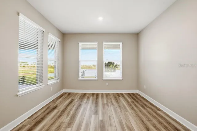 a view of a room with wooden floor and windows