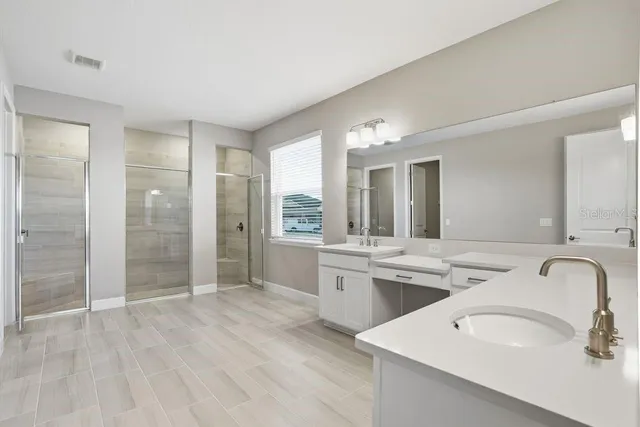a bathroom with a granite countertop sink mirror and bathtub