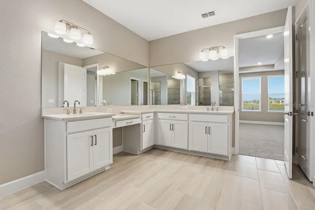a large bathroom with a large mirror vanity and shower