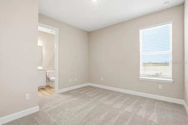 an empty room with a window and a bathroom