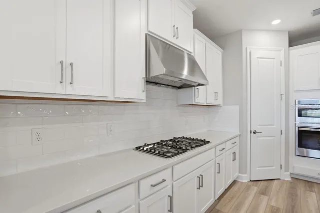 a kitchen with white cabinets and appliances