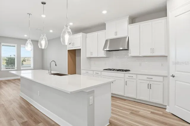 a kitchen with kitchen island a stove a sink and a refrigerator