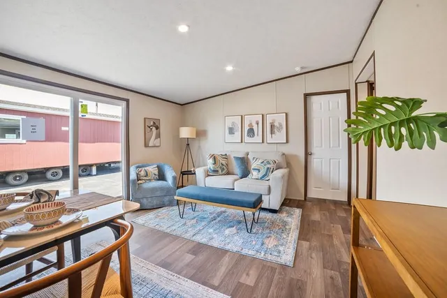 a living room with furniture floor to ceiling window and wooden floor