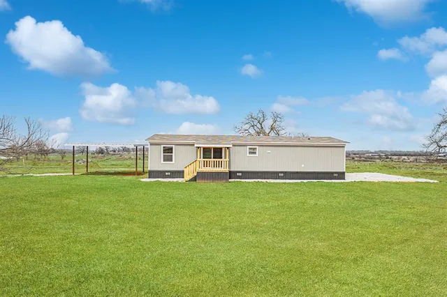 a front view of a house with a garden and yard