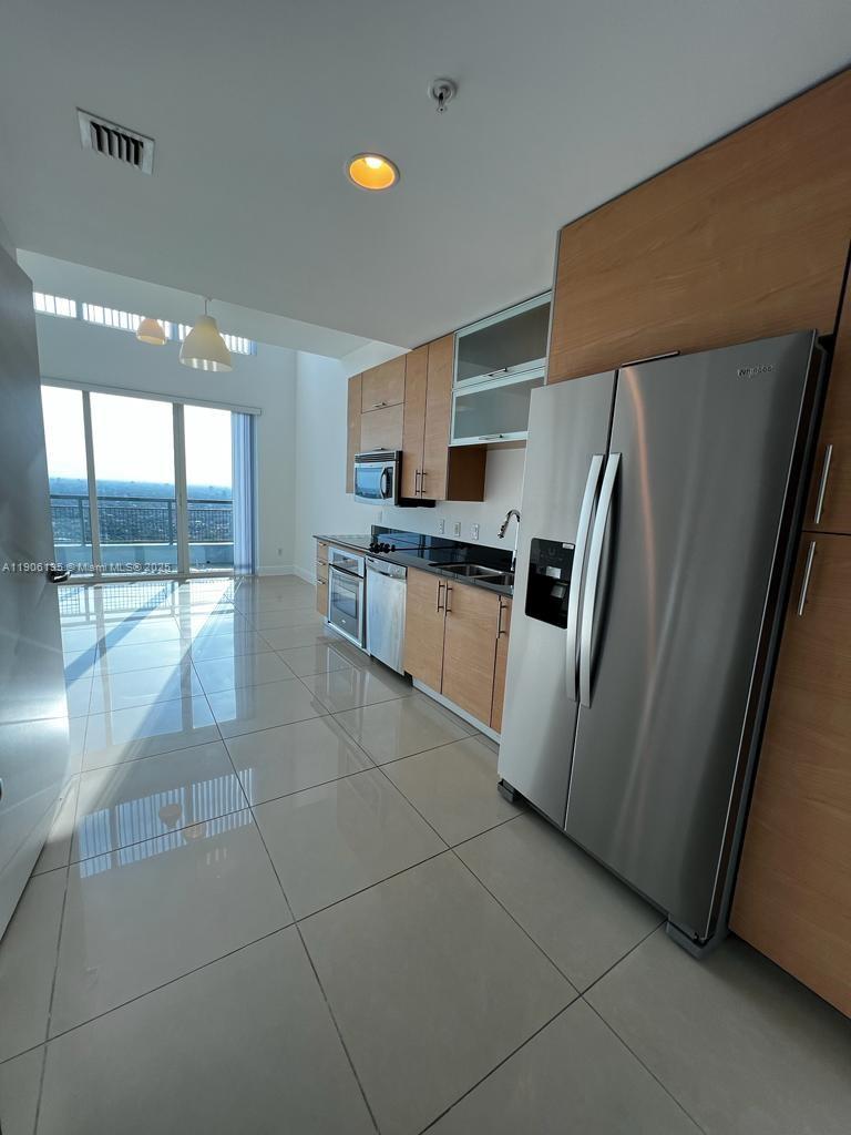 60 Southwest 13th Street, Unit 3003 Miami, FL 33130 - Photo 3 of 17 a kitchen with stainless steel appliances a refrigerator and a stove top oven