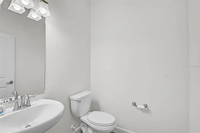 a bathroom with a toilet a sink and mirror