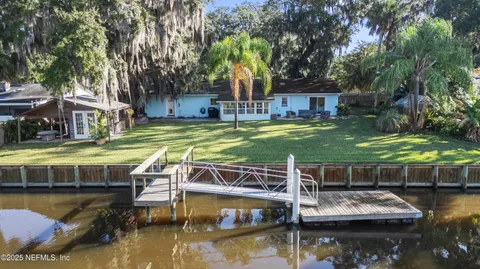 a view of house with swimming pool and a yard