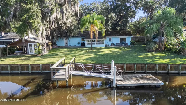 a view of house with swimming pool and a yard