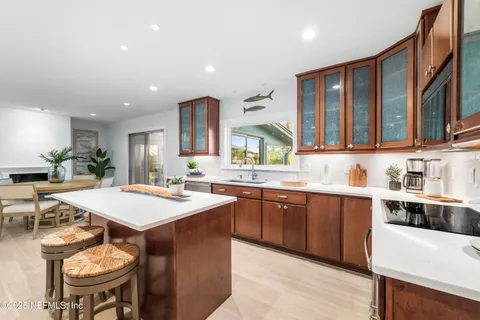 a large kitchen with kitchen island a sink table and chairs