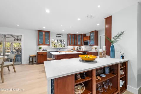 a kitchen with stainless steel appliances granite countertop a table chairs and a living room view
