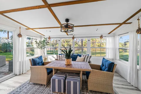 a dining room with furniture a flat screen tv and a large window
