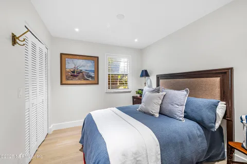 a bedroom with a large bed and a painting on the wall