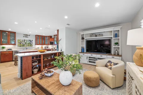 a living room with kitchen furniture and a flat screen tv