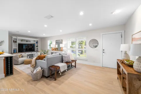 a living room with furniture a flat screen tv and a window