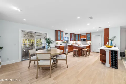 a room with stainless steel appliances kitchen island granite countertop lots of furniture and wooden floors