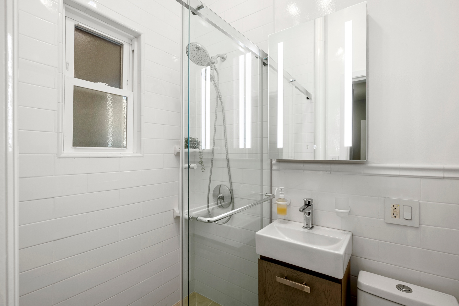 237 East 88th Street, Unit 101 Manhattan, NY 10128 - Photo 12 of 17 a bathroom with a sink a toilet and a mirror