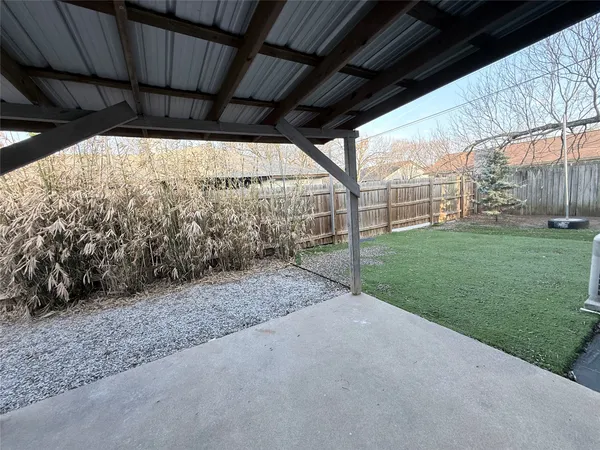 a view of a backyard with wooden fence