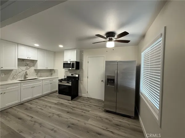 a kitchen with a refrigerator and a stove top oven