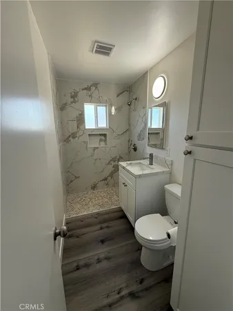 a bathroom with a toilet a sink and mirror