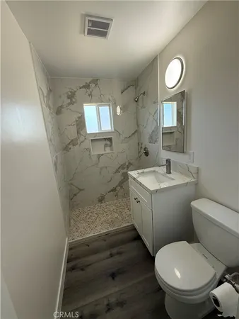 a bathroom with a sink a toilet and a mirror