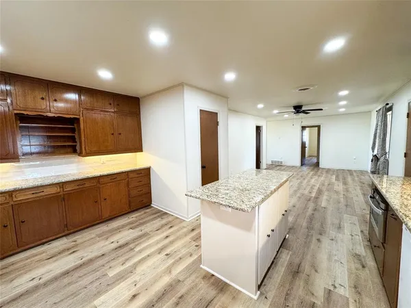 a large kitchen with stainless steel appliances kitchen island a large counter top and a stove top oven