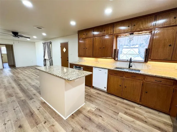 a kitchen with granite countertop a sink and cabinets