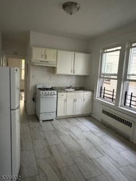231 Alexander Street, Unit 1R Newark, NJ 07106 - Photo 8 of 9 a kitchen with stainless steel appliances granite countertop a stove a sink and a refrigerator