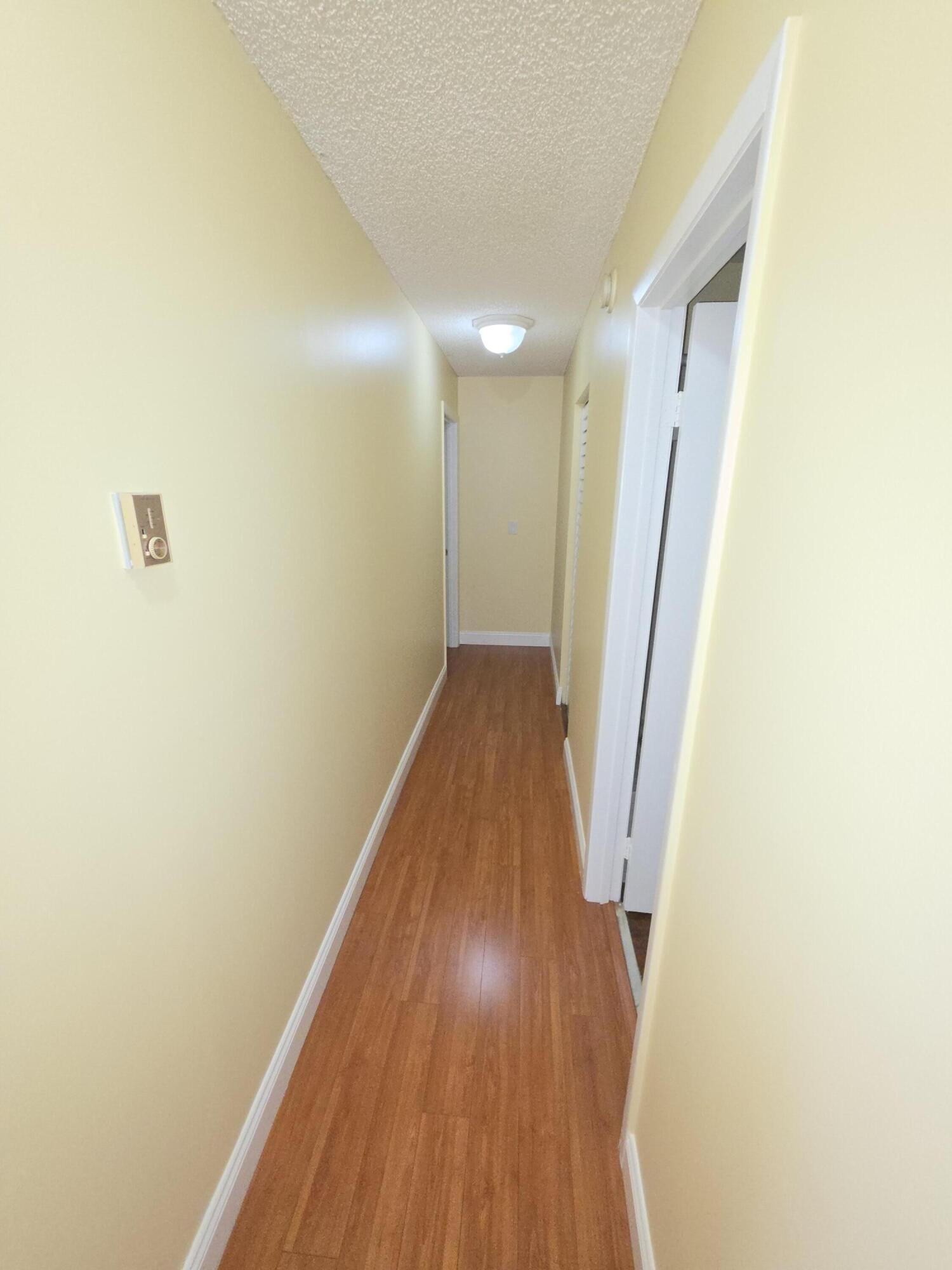 401 Springdale Circle Palm Springs, FL 33461 - Photo 12 of 31 a view of a hallway with wooden floor