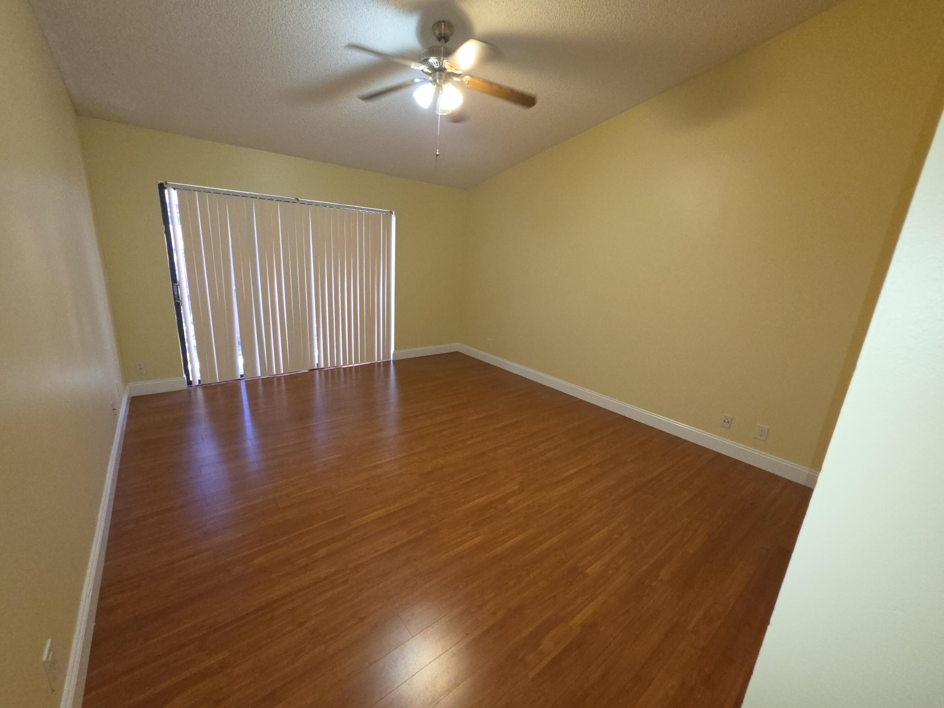 401 Springdale Circle Palm Springs, FL 33461 - Photo 15 of 31 a view of an empty room with wooden floor and a window