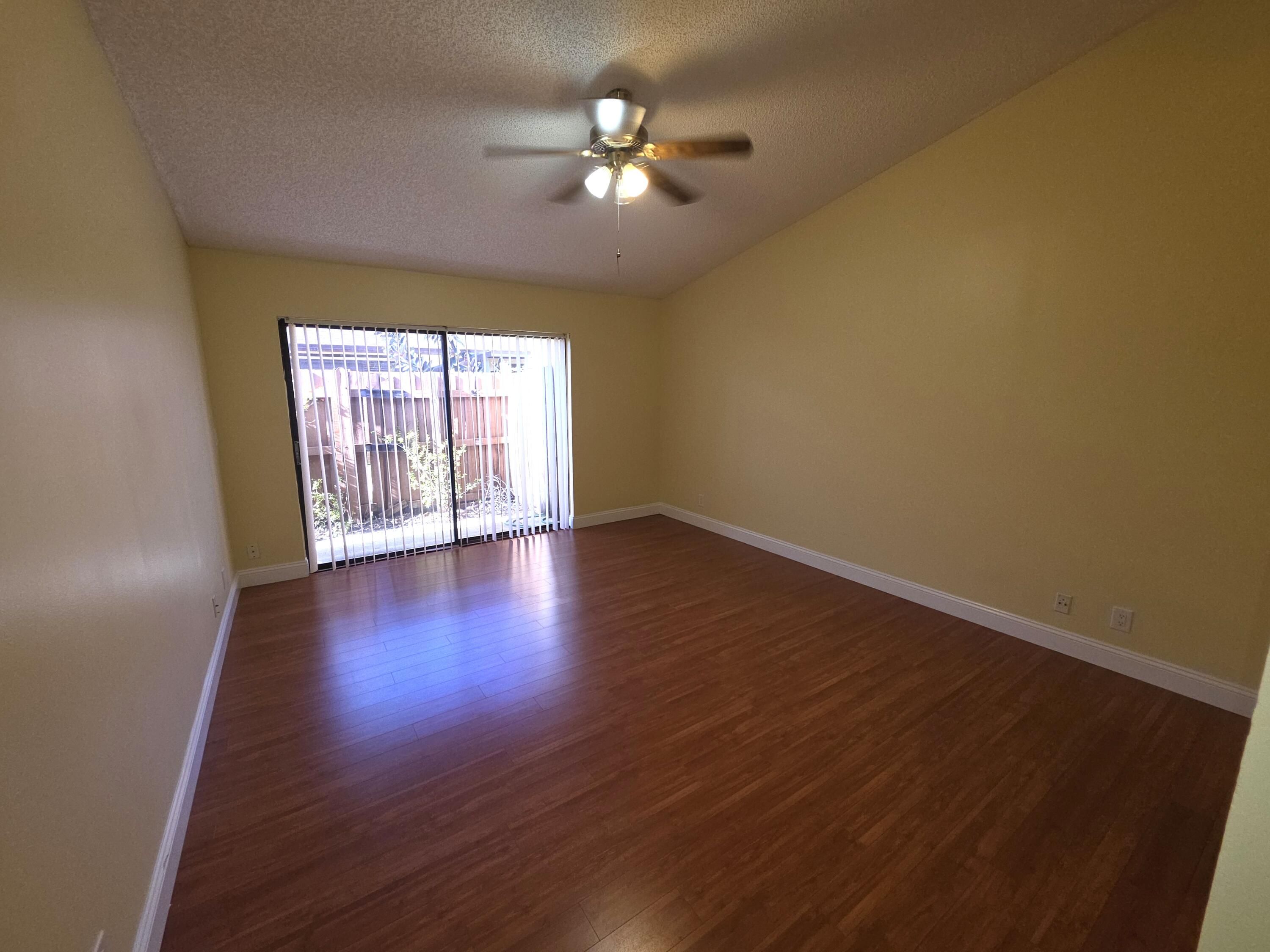 401 Springdale Circle Palm Springs, FL 33461 - Photo 16 of 31 a view of an empty room with wooden floor and a window