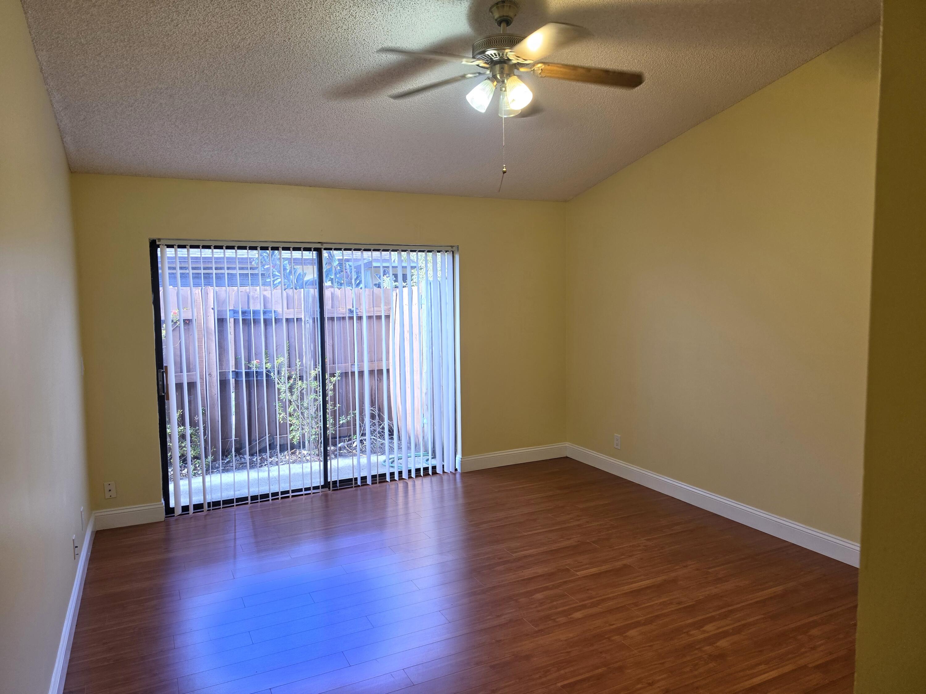 401 Springdale Circle Palm Springs, FL 33461 - Photo 17 of 31 an empty room with wooden floor and windows