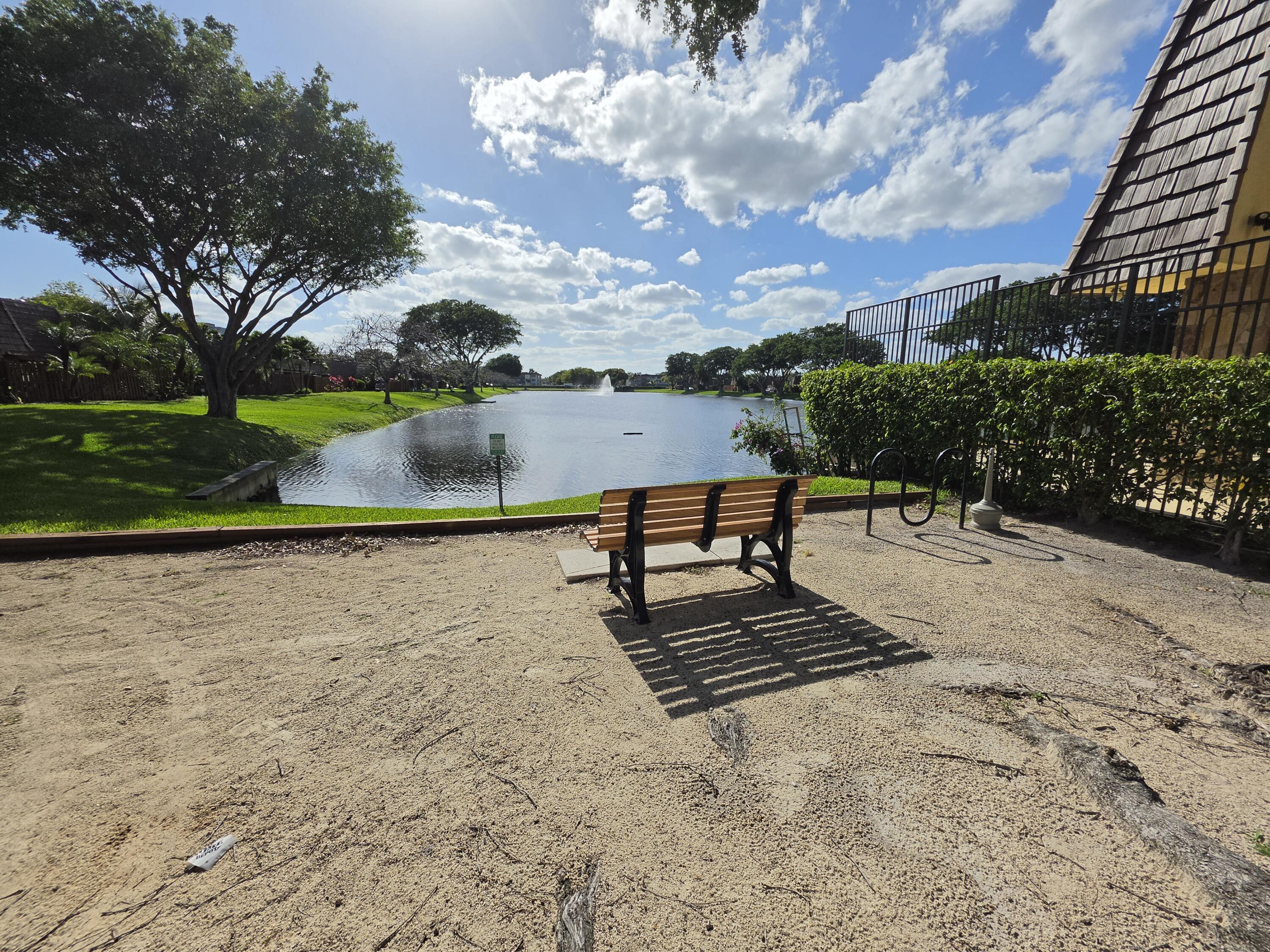 401 Springdale Circle Palm Springs, FL 33461 - Photo 30 of 31 a bench is sitting in the middle of a lake