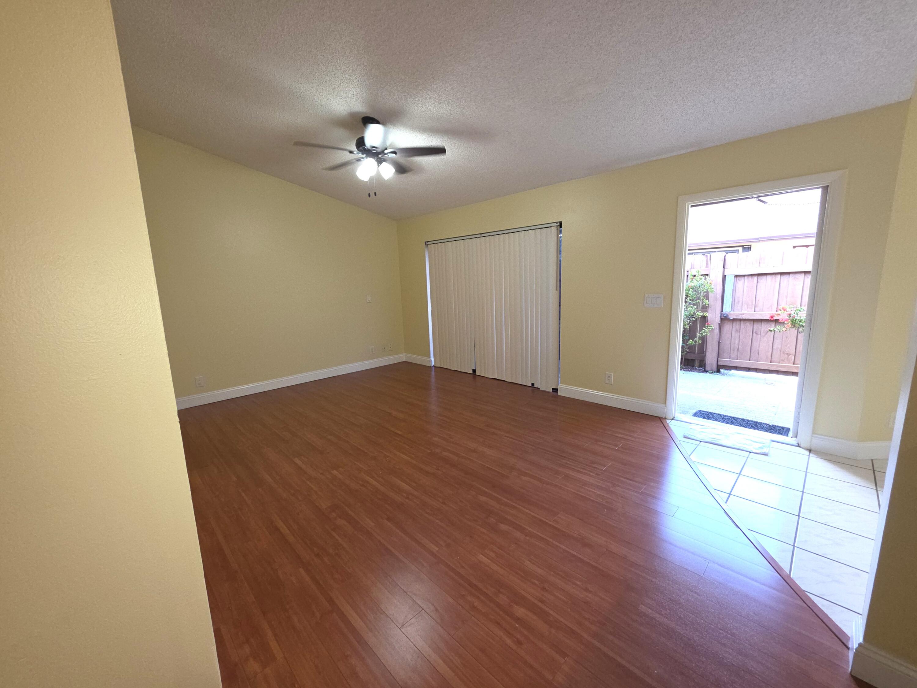 401 Springdale Circle Palm Springs, FL 33461 - Photo 4 of 31 wooden floor in an empty room with a window