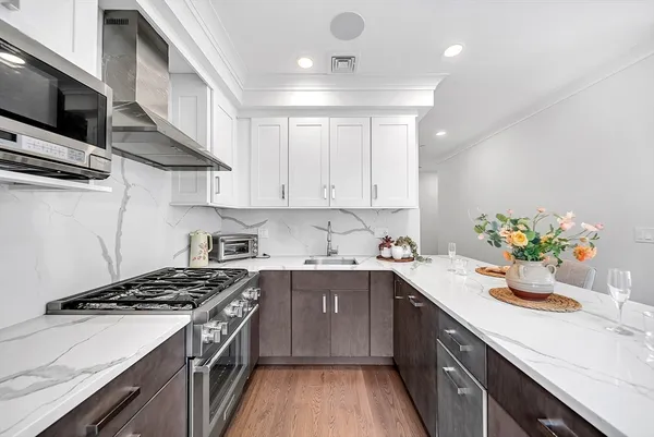 a kitchen with stainless steel appliances a sink a stove and cabinets