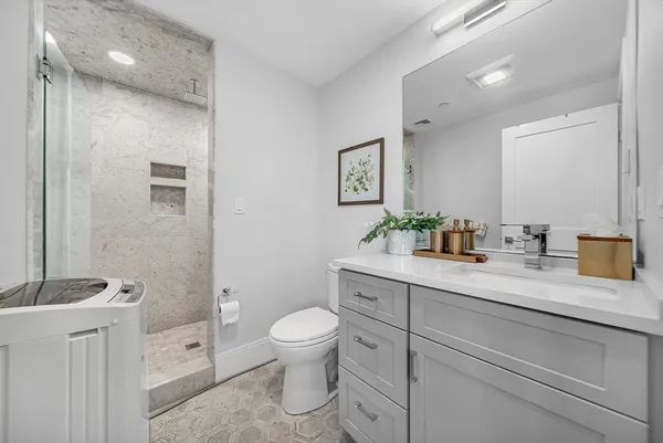 a bathroom with a toilet a sink a mirror and vanity