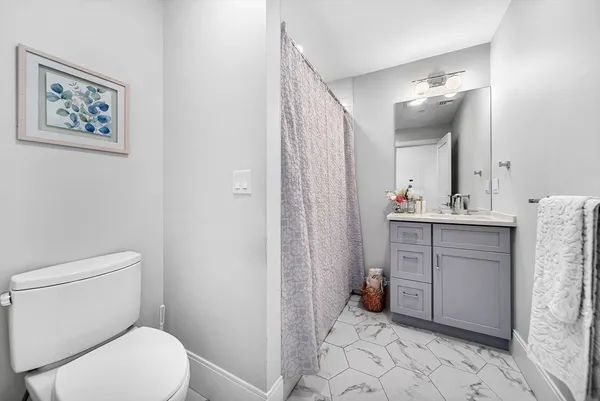 a bathroom with a toilet sink and mirror