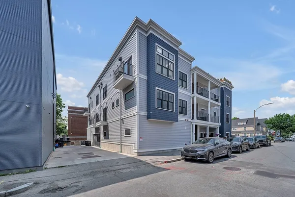 a couple of cars parked in front of brick building