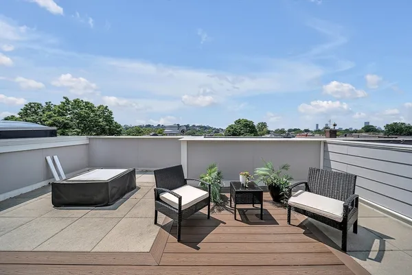 an outdoor sitting area with furniture and city view