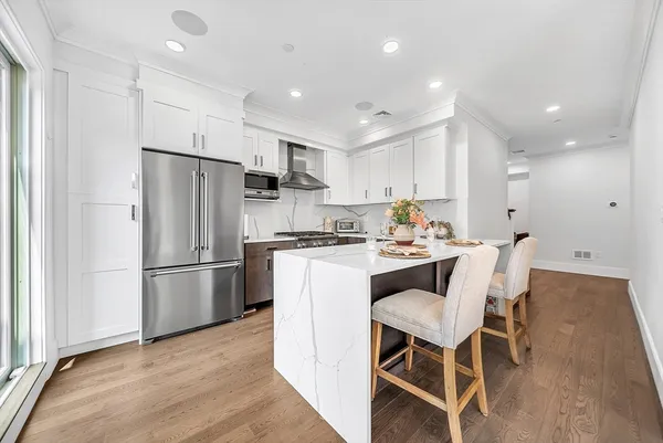 a kitchen with a refrigerator a dining table and chairs