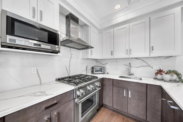 a kitchen with stainless steel appliances a sink a stove and cabinets