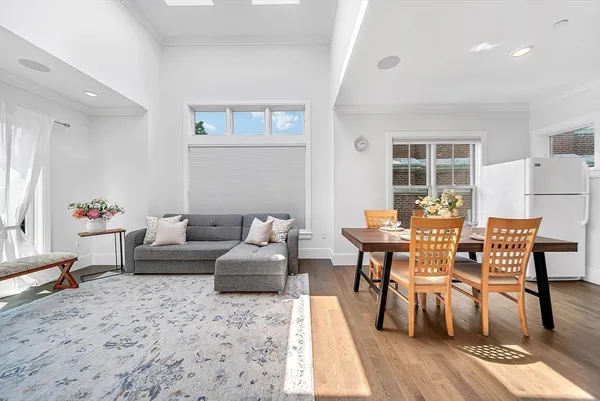 a living room with furniture wooden floor and a dining table