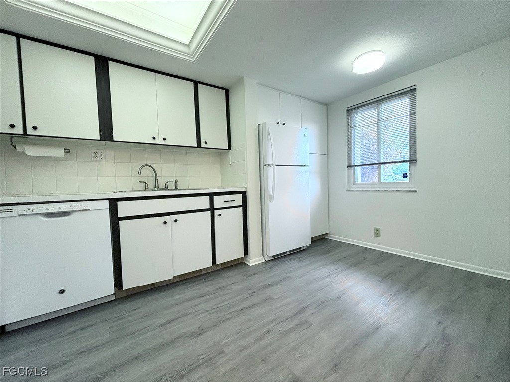 2264 Winkler Avenue, Unit 107 Fort Myers, FL 33901 - Photo 4 of 17 a view of cabinets a wooden floor and a window