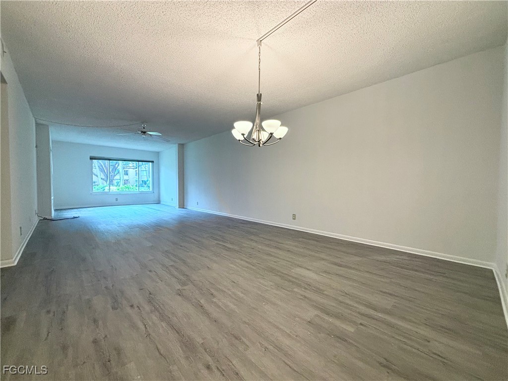 2264 Winkler Avenue, Unit 107 Fort Myers, FL 33901 - Photo 5 of 17 a view of a room with wooden floor and chandelier