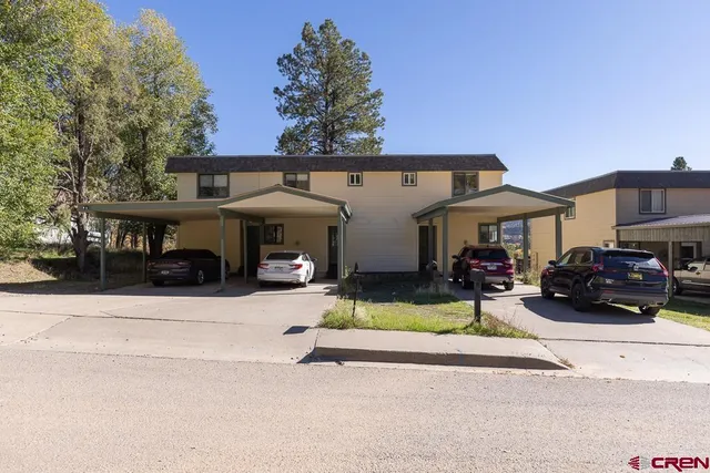a view of a house with a patio and a yard