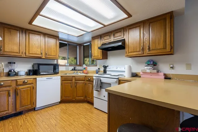 a kitchen with a stove cabinets and wooden floor