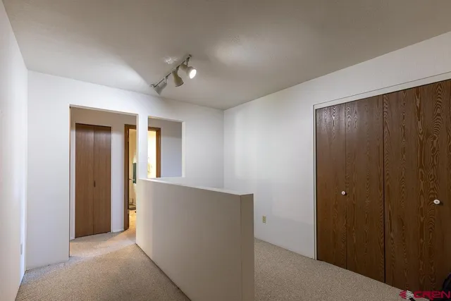 a bedroom with bed and a flat tv screen on dresser