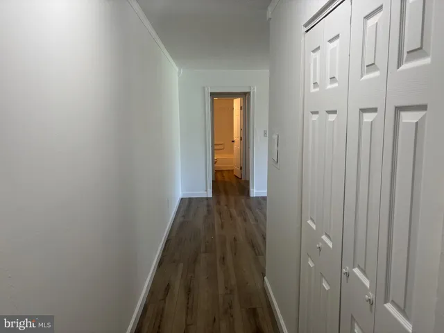 a view of a hallway with wooden floor