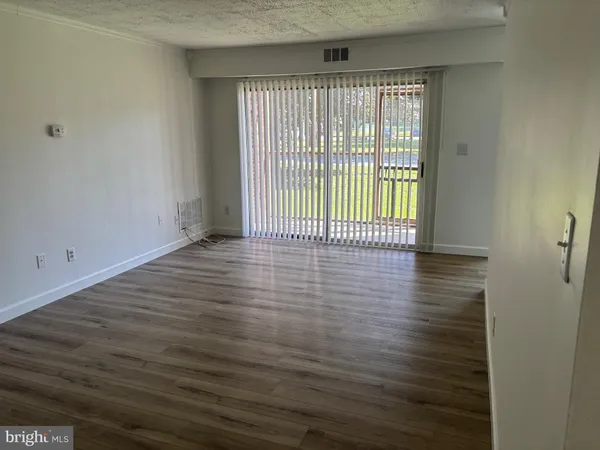 a view of a room with wooden floor and a window